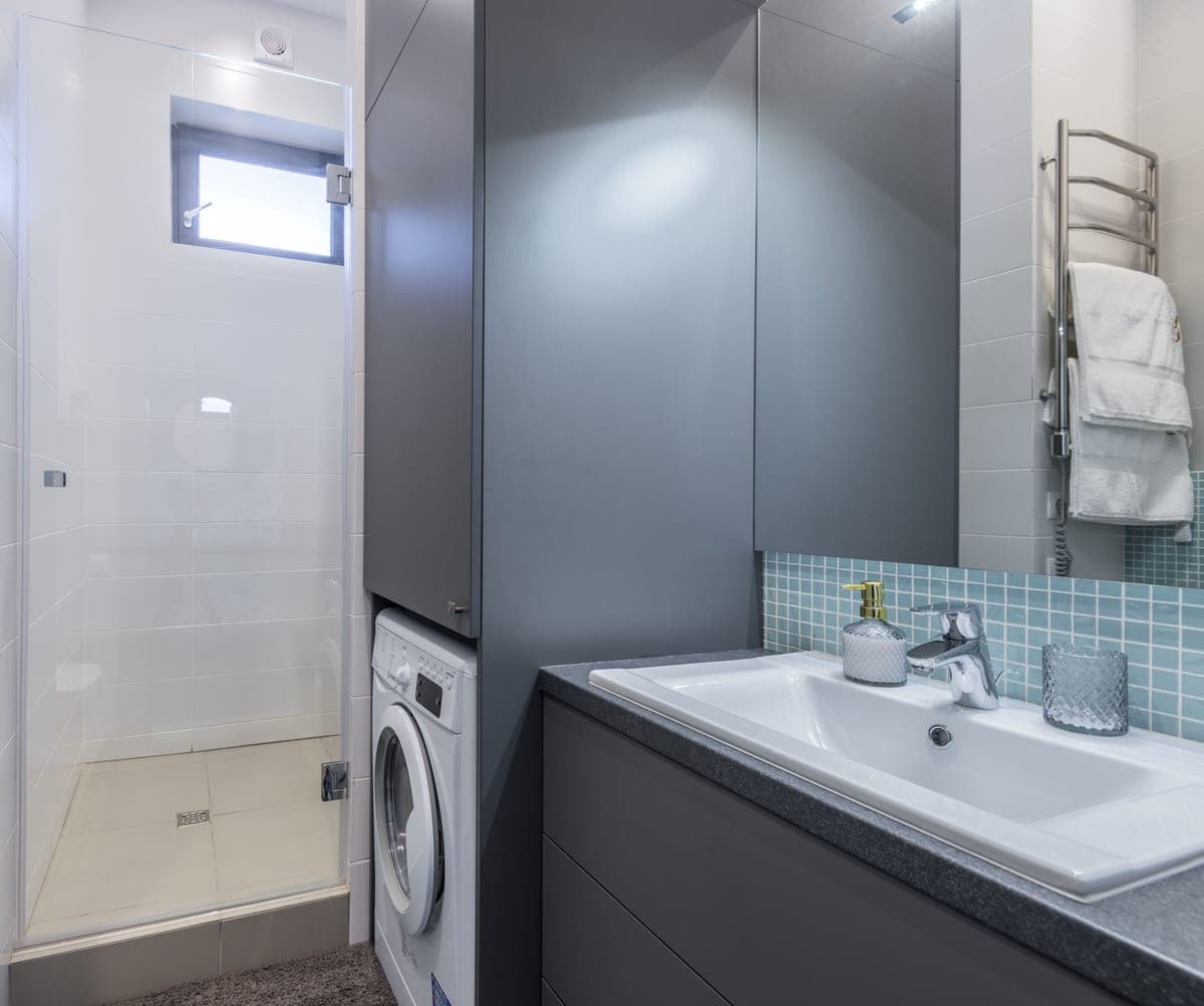 A compact bathroom with a washing machine built in