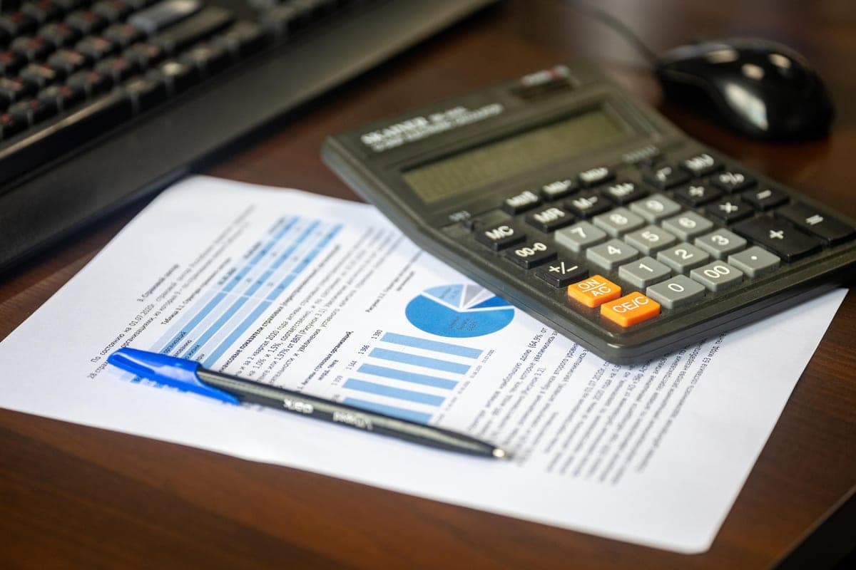 A calculator sitting on printed figures and paperwork