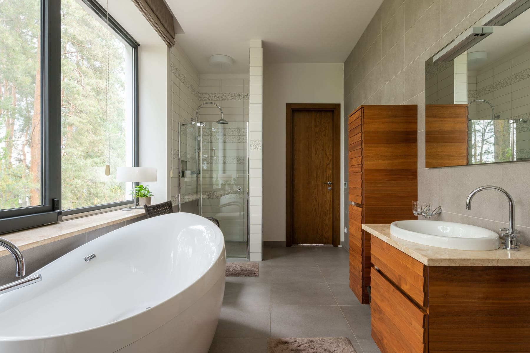 A bright bathroom with a large window and a clean white bathtub