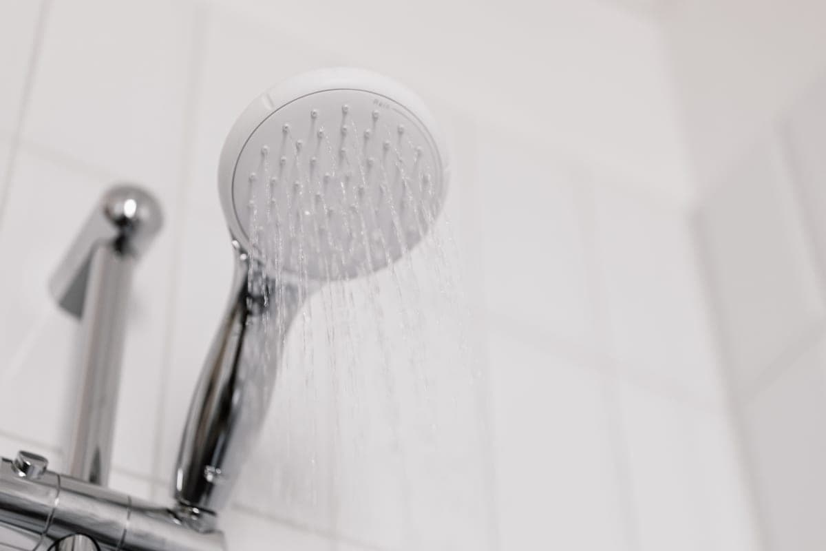 A close view of a shower head with water running