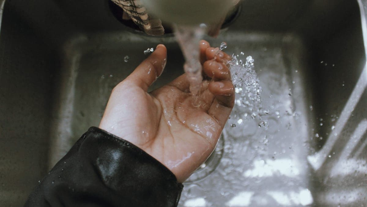 A hand held under running water from a tap